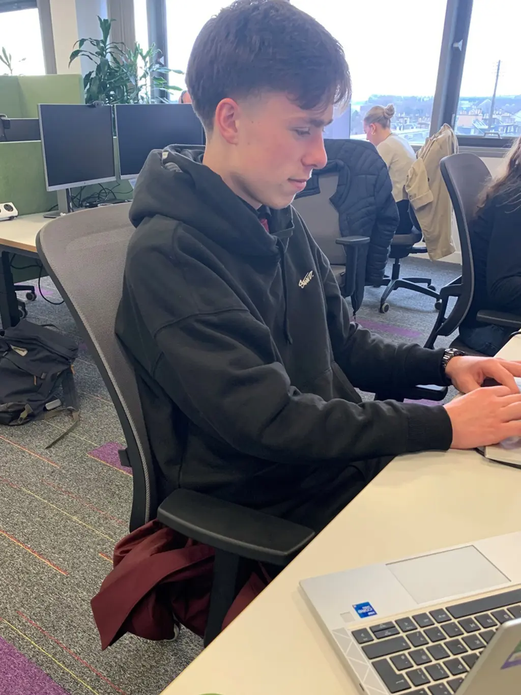 Apprentice on a laptop in office.