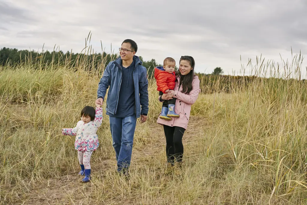 Young family walking at Tentsmuir beach.