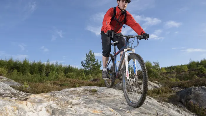 Person on mountain bike on top of a rock feature.