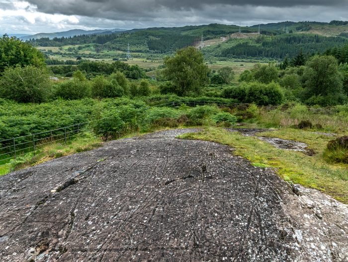 Stone cut marks on a hill with a rolling treed background 