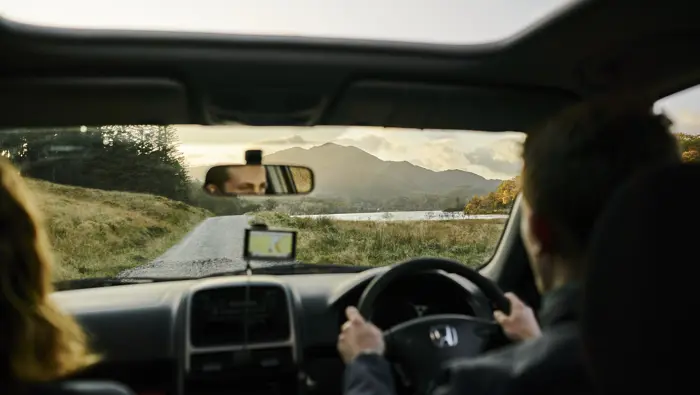 View from inside a car looking to hills in the distance.