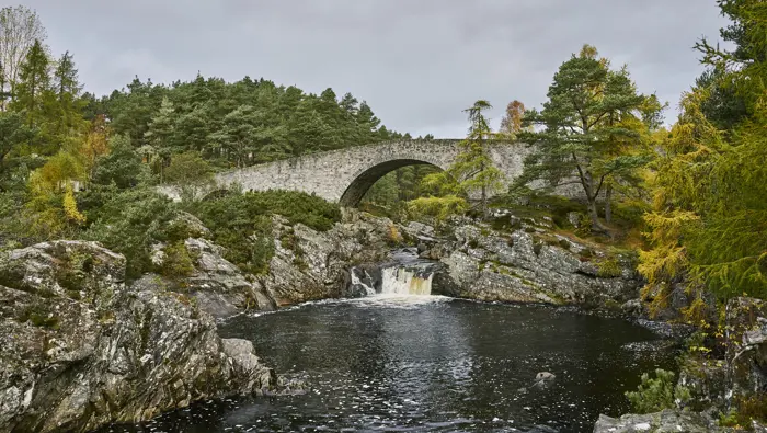 Bridge above a waterfall and river.