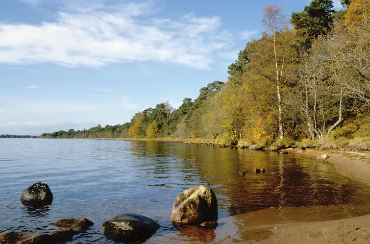 A loch with beach and rocks in the foreground