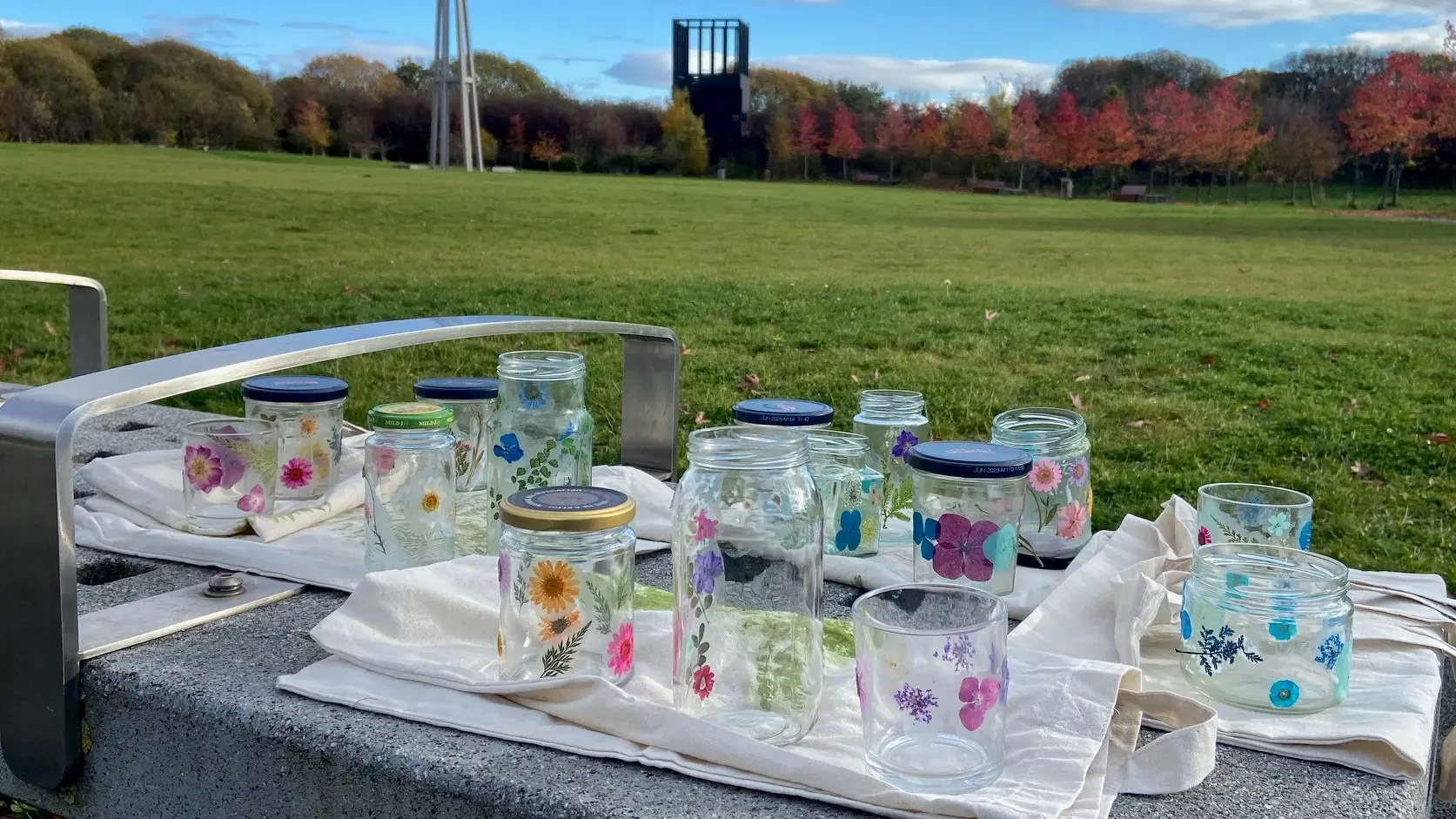 A close up view of glass jars with flowers pressed on as decoration.