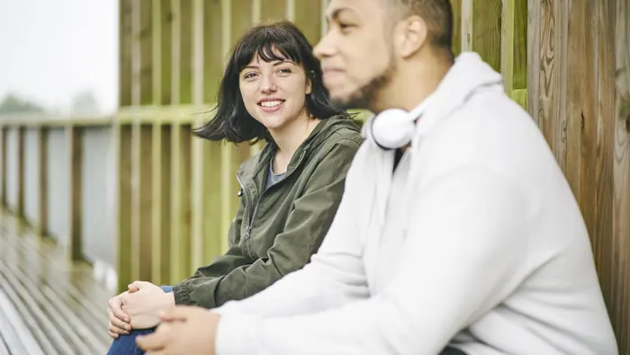 Man and woman sit together in wooden shelter at Larbert Woods in grounds of Forth Valley Royal Hospital, Larbert