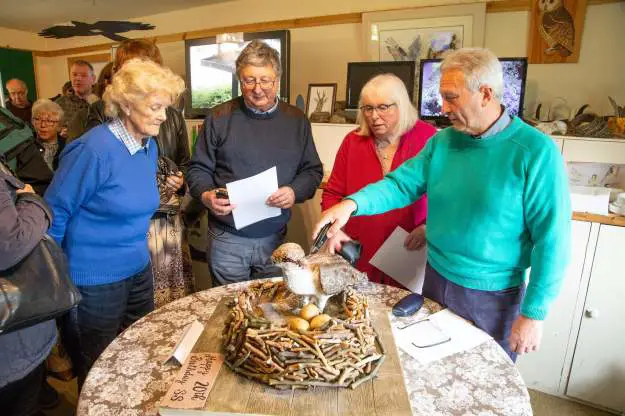 Four people stand around a cake