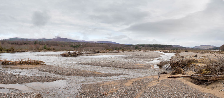 A river landscape with hills in the background