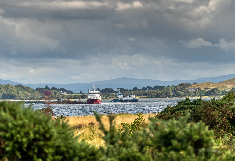  Ships docked in the sea with grass and gorse with islands