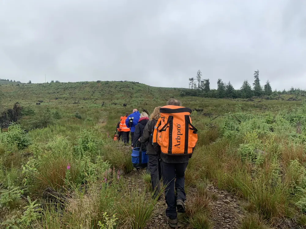 staff and camera crew walking through flat landscape