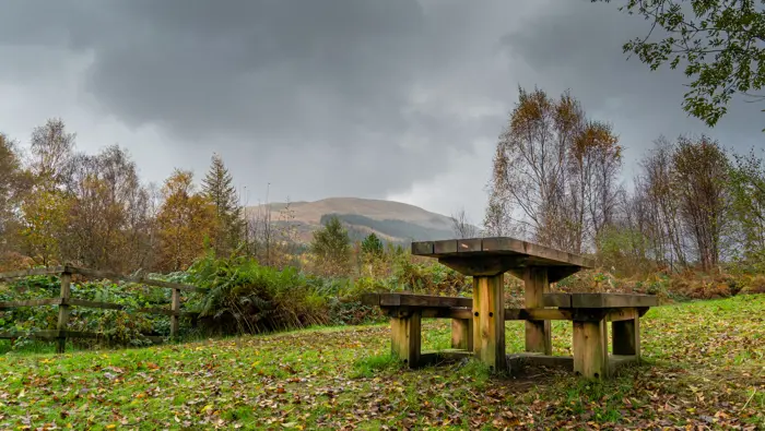 A picnic table with a mountain behind