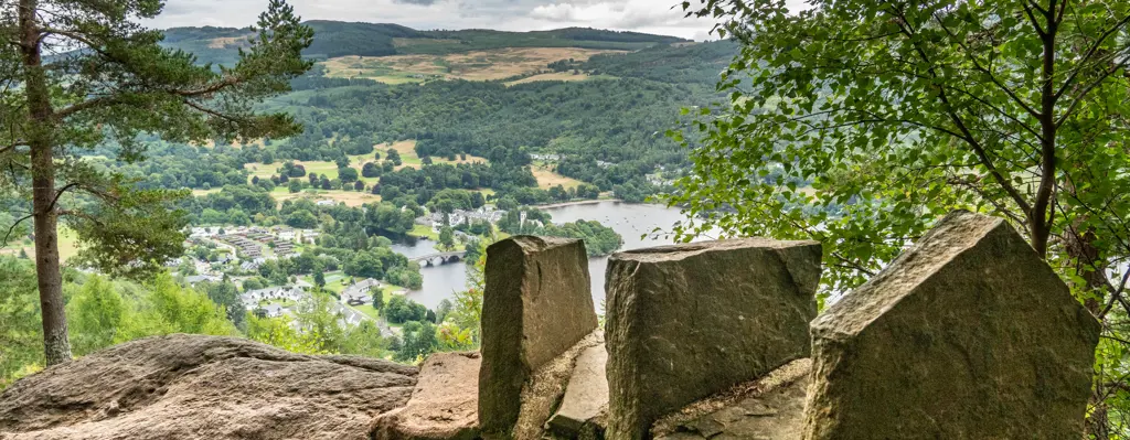 Viewpoint looking over a loch to hills in the distance.